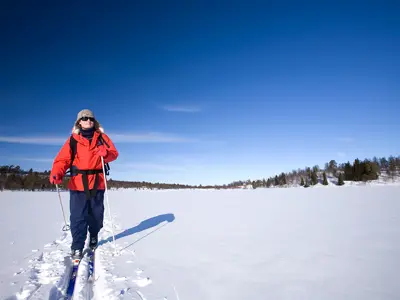 Woman in red jacket cross-country skiing in wide space