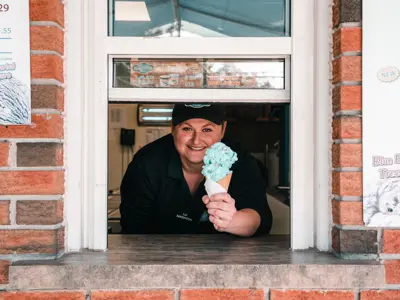 Lady serving Kawartha Dairy ice cream out a serving window