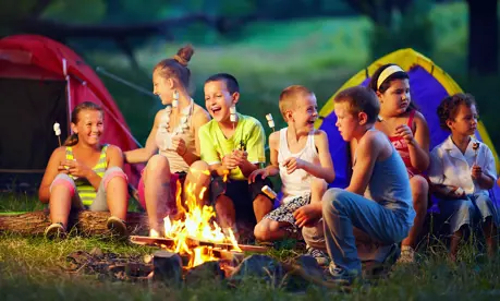 Kids eating marshmallows around a campfire